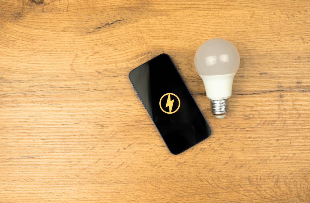 Led Light Bulb and Smartphone on a Wooden Table