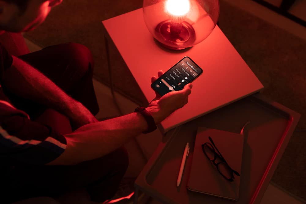 Man Controlling a Smart Lamp With His Phone